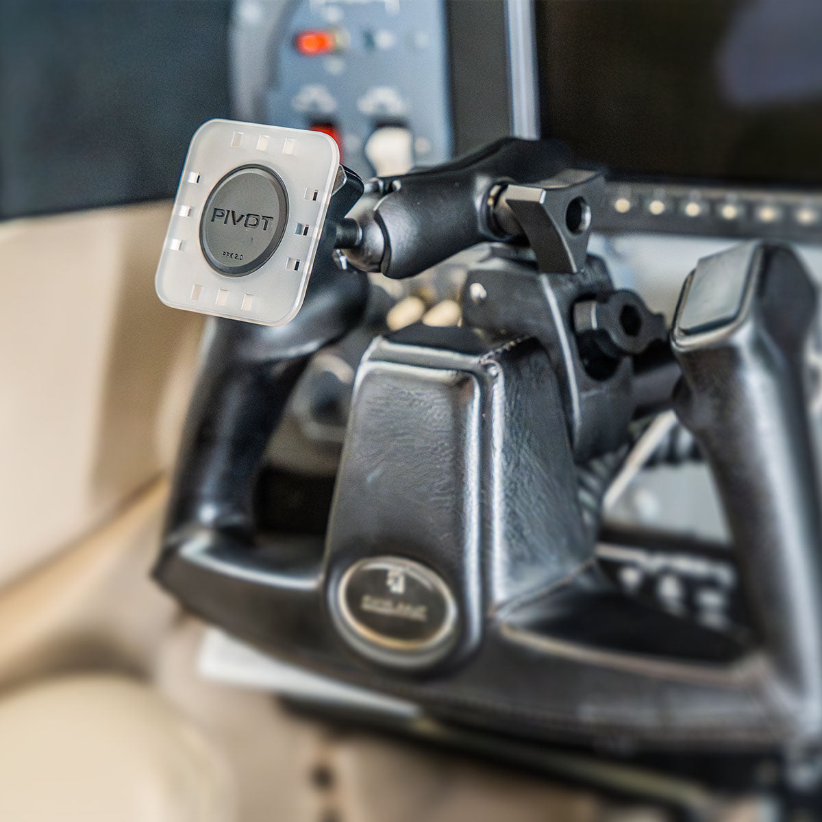 Close-up view of a PIVOT device mount attached to an airplane's control yoke, with the cockpit's control panel partially visible in the background. The mount is designed to securely hold a device, providing hands-free operation for the pilot.