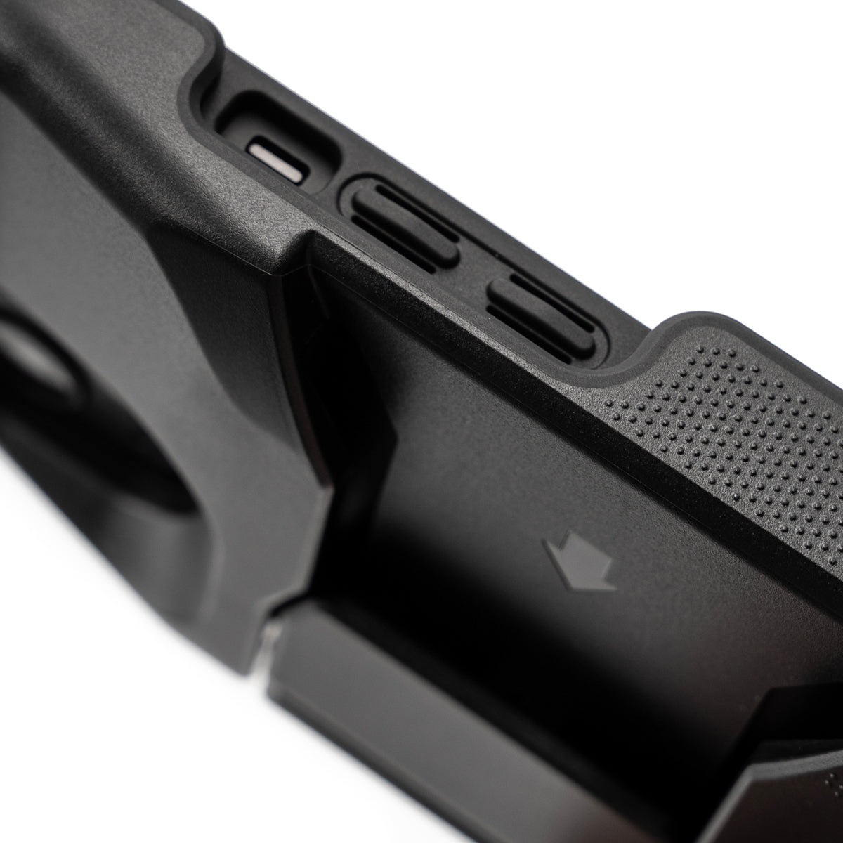 Close-up of a black PIVOT M23A showing the side buttons and a textured grip area. The side buttons include openings for volume adjustment and other functionality. Designed for iPhone 13, it does not fit Pro or iPhone 14 models.