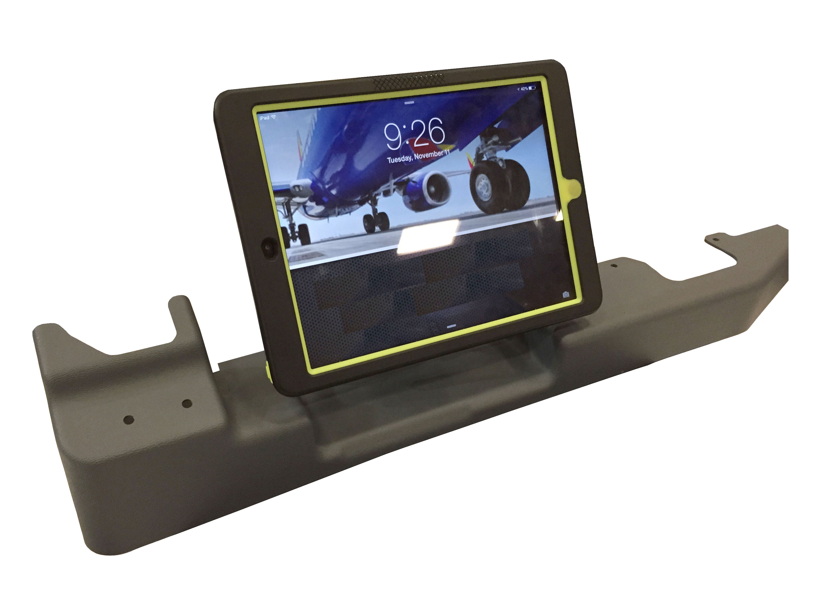 A tablet displaying a close-up image of an airplane's landing gear is mounted on a grey, device-specific stand. The tablet's screen shows the time as 9:26 with the date "Tuesday, November 8." The stand has a robust design, likely for secure placement.