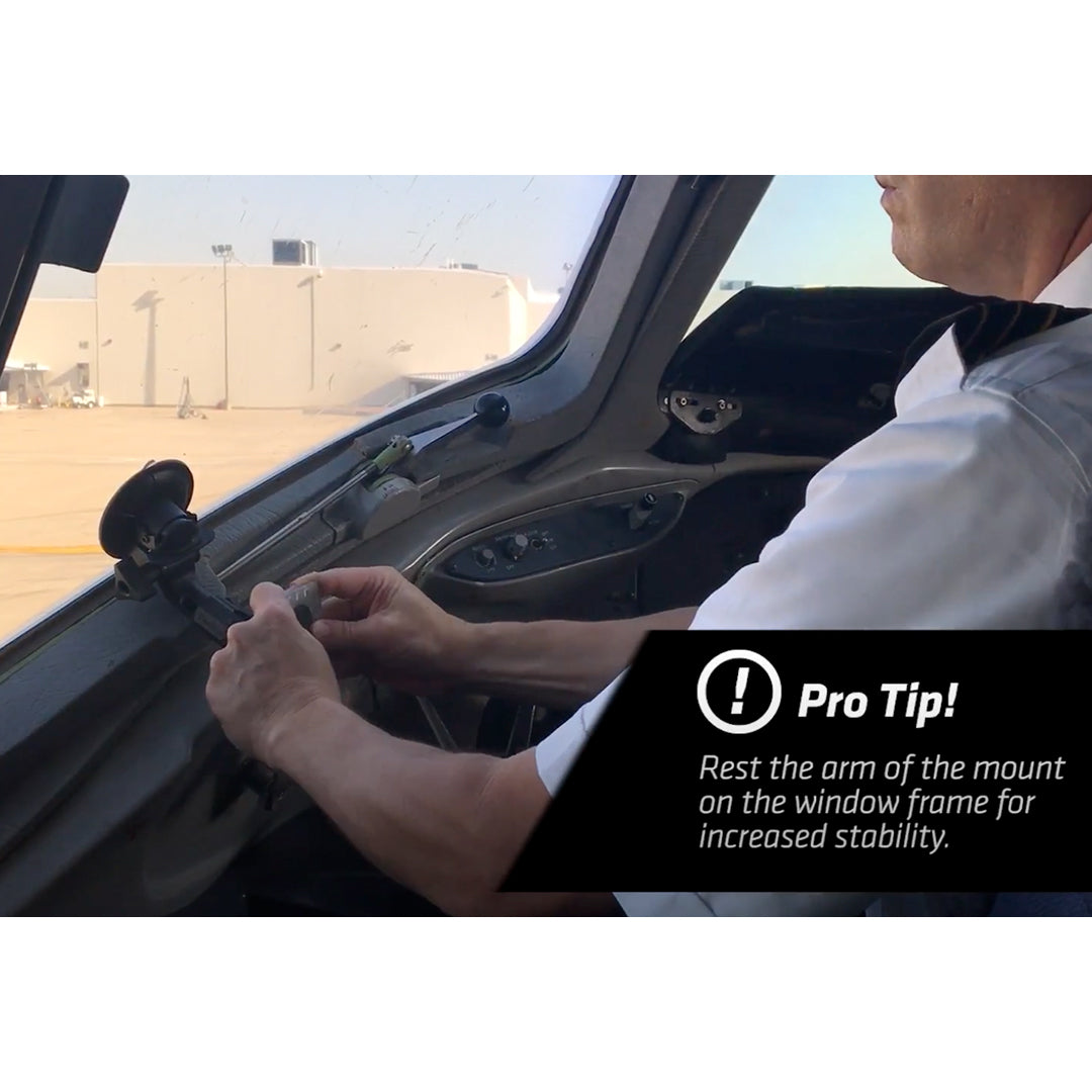 A person is adjusting a PIVOT Single Suction Cup Mount attached to the window frame inside an aircraft cockpit. A text overlay reads, "Pro Tip! Rest the arm of the mount on the window frame for increased stability.