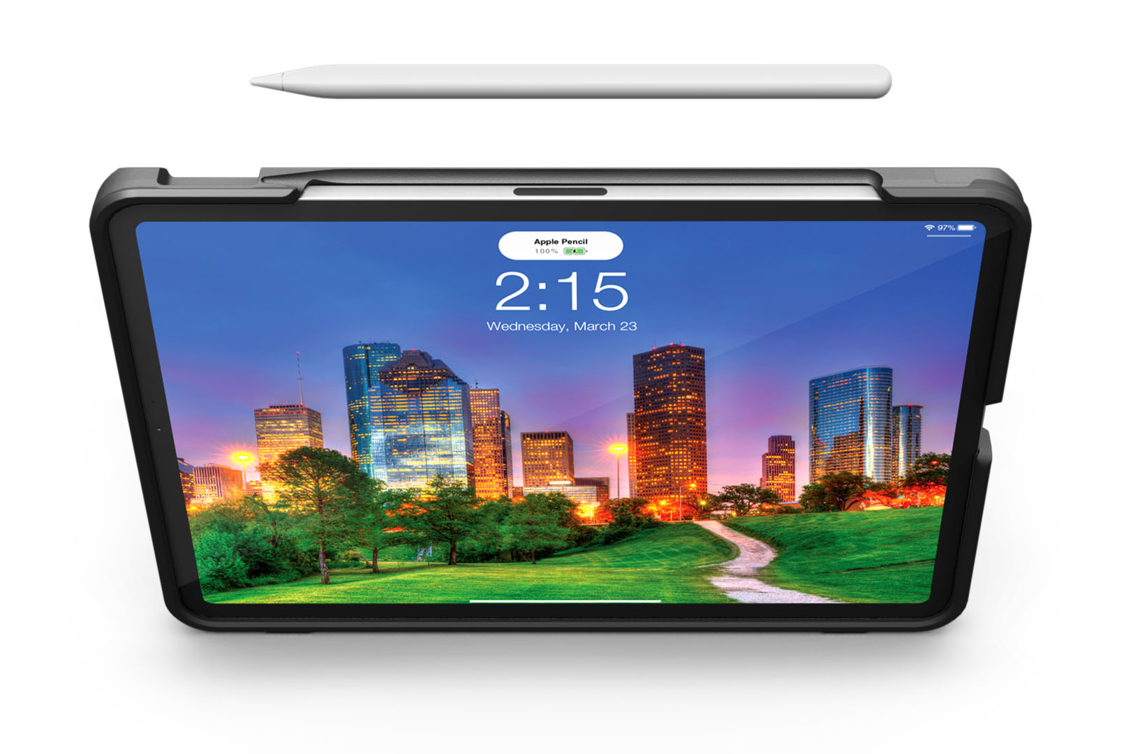 A PIVOT PRO 11 (1st generation) in a protective case with a stylus hovering above it displays the time as 2:15 with a scenic cityscape wallpaper. The background shows tall buildings and a grassy park with trees, set against a vibrant sunset sky.